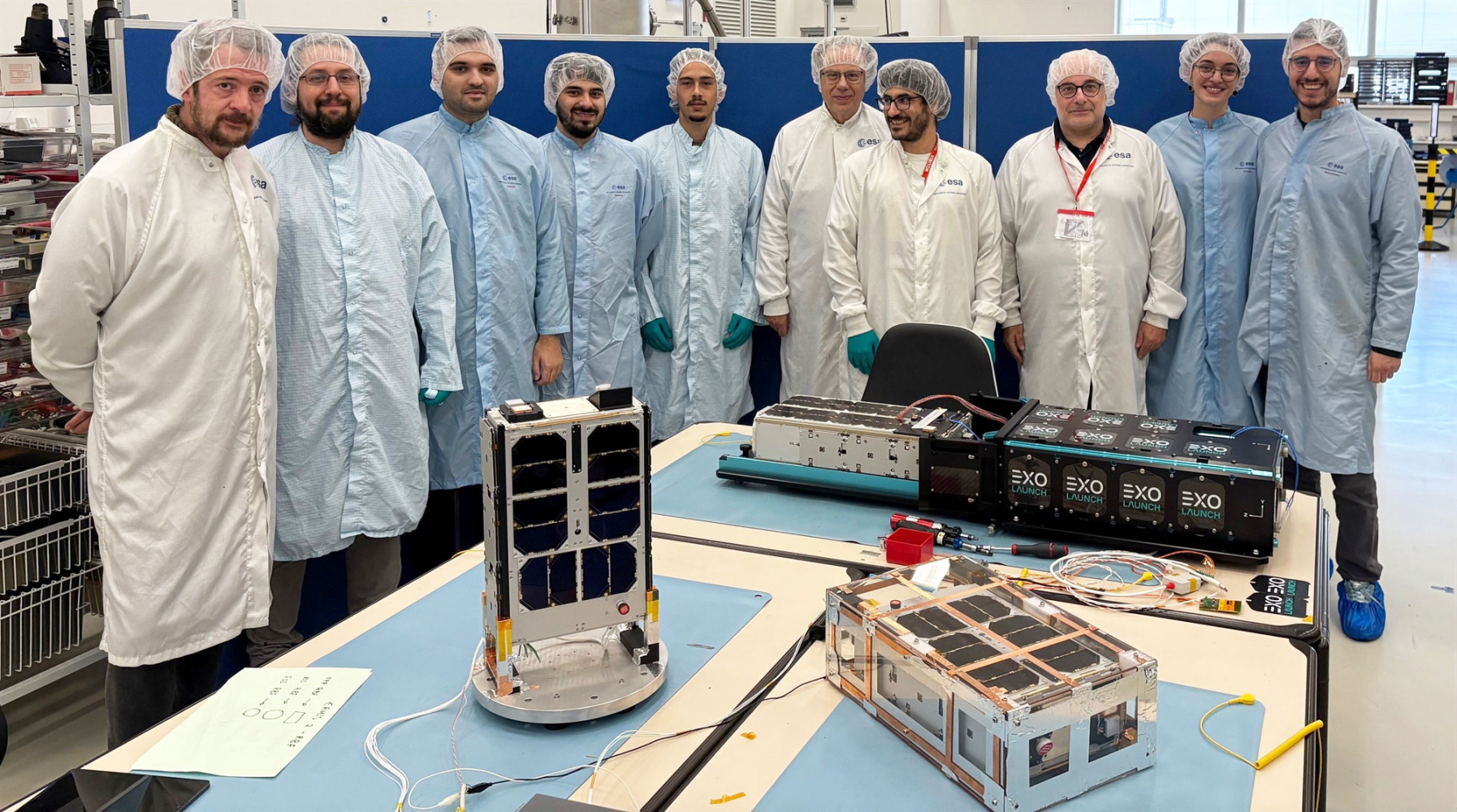 Οικογενειακή φωτογραφία με μέλη της επιστημονικής ομάδας που κατασκευάζουν τους νανοδορυφόρους Ερμής, οι οποίοι ζυγίζουν περίπου 10 κιλά έκαστος και έχουν διαστάσεις 10x20x30 και 10x20x40 εκατοστών.